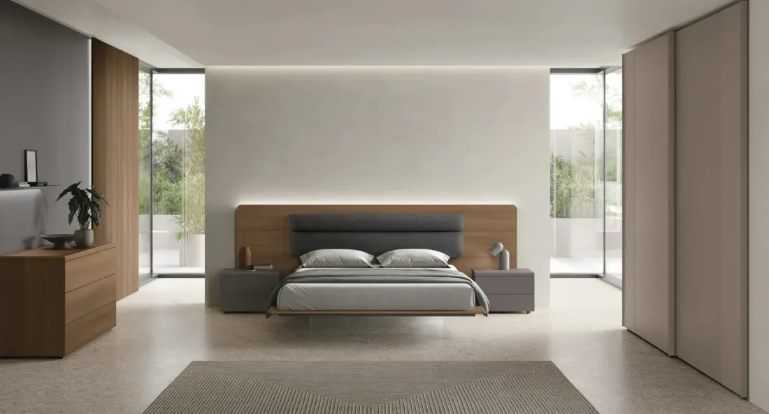 Camera da letto con testiera in legno a tutta parete e armadio a filo muro, affacciata sul giardino