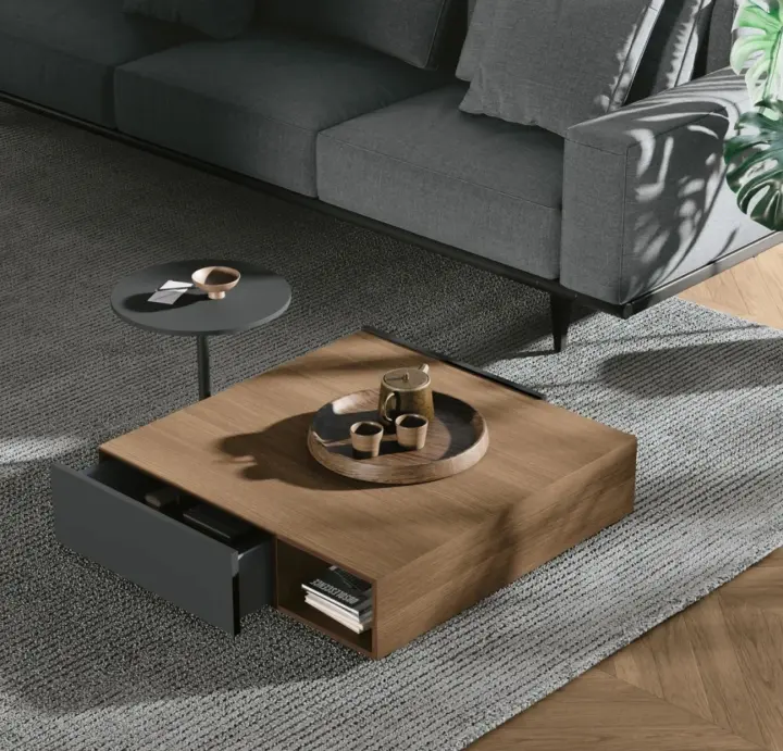 Tavolino da salotto quadrato in legno con cassetto estraibile, davanti a un divano grigio