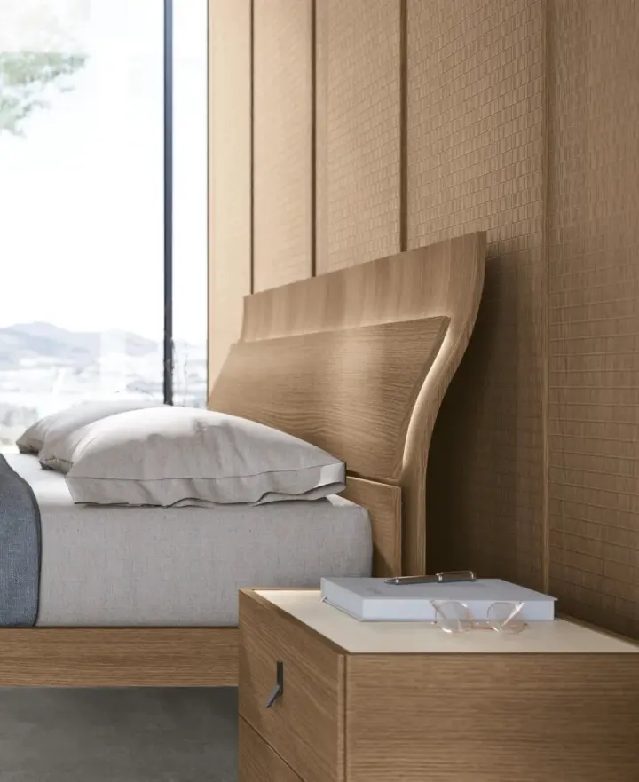 Letto con testiera in legno sagomato e comodino sospeso nella stessa finitura
