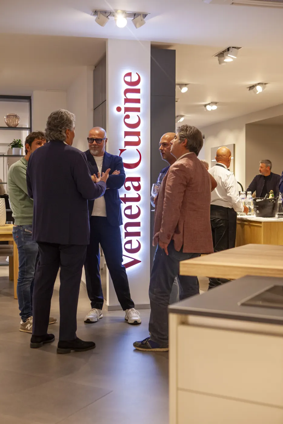 Un gruppo di ospiti accanto all’insegna luminosa Veneta Cucine, durante la serata