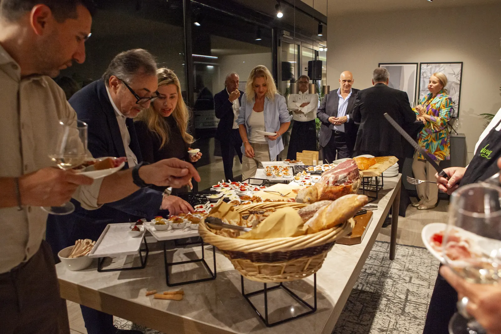 Il buffet della serata di apertura nello showroom di Manno, con gli ospiti attorno al tavolo