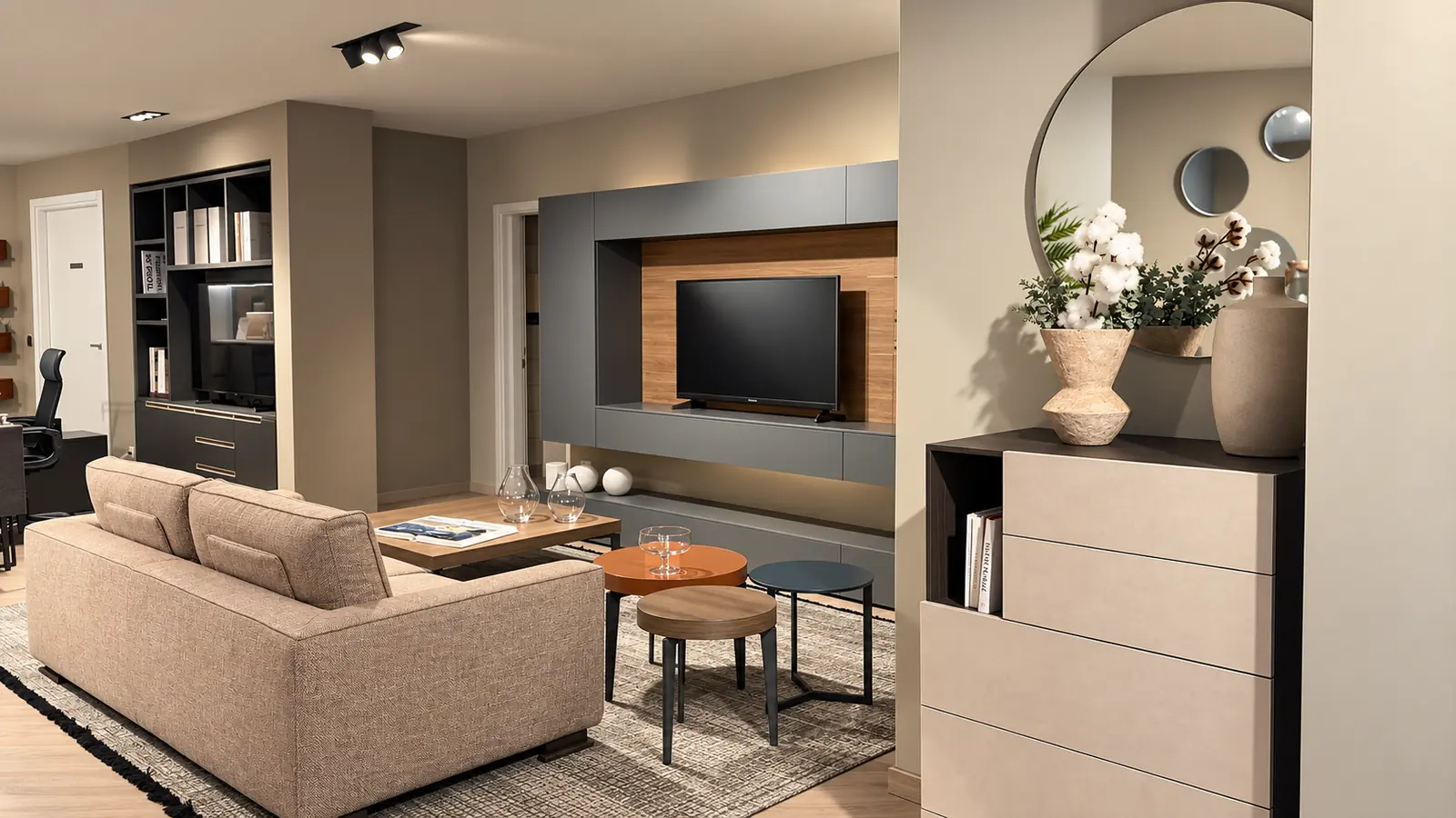 Due angoli dello showroom: il salotto con parete attrezzata e una cassettiera con specchio ad arco