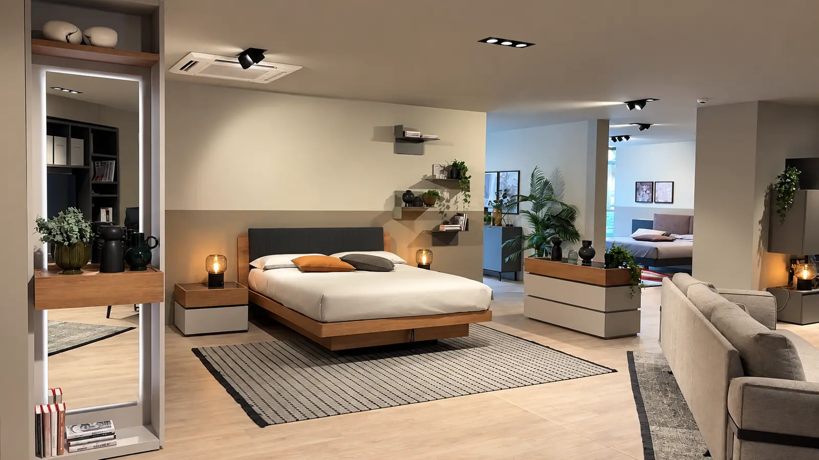 Camera da letto allestita con letto in legno, comodini sospesi e piante