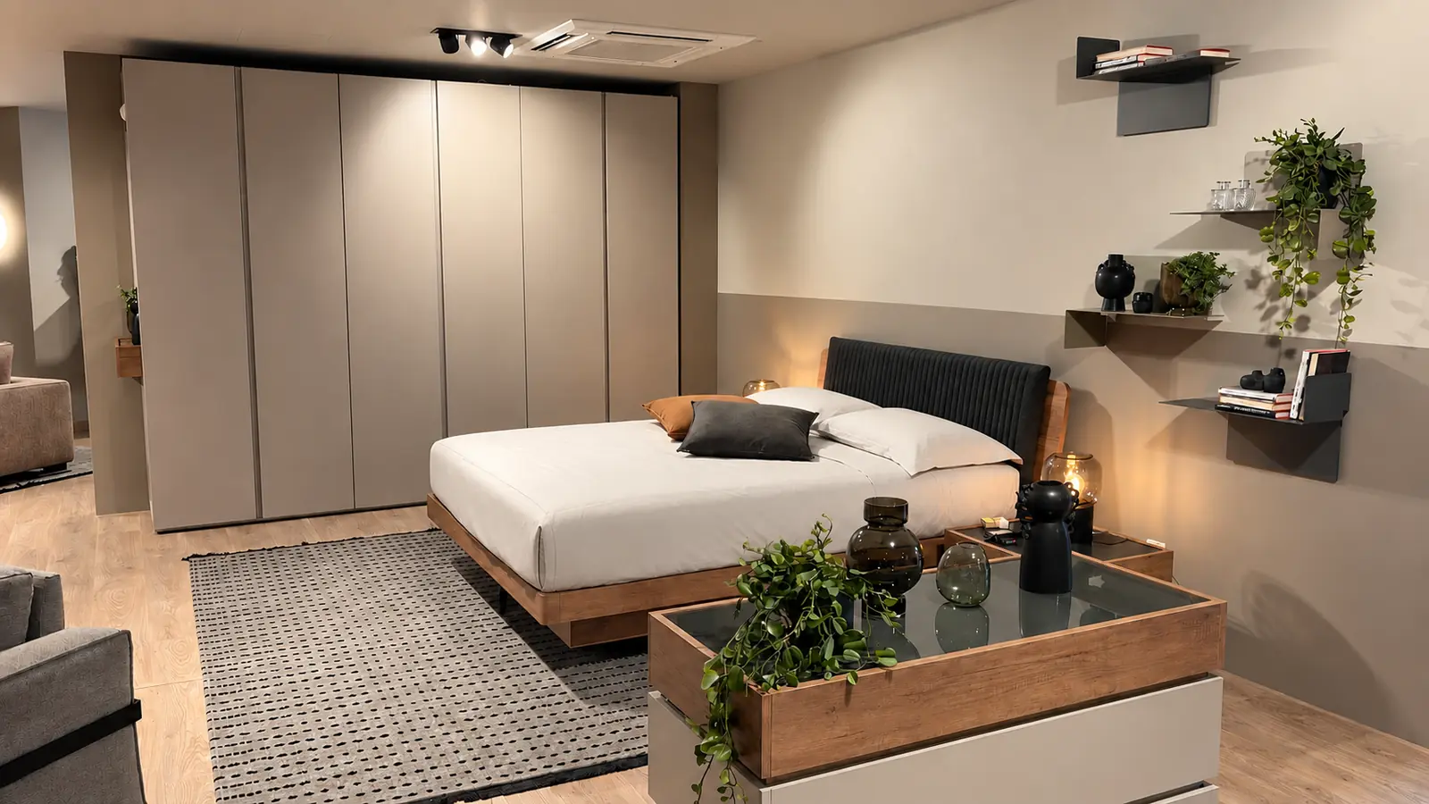 Camera con parete di armadi a filo muro e letto matrimoniale, nello showroom