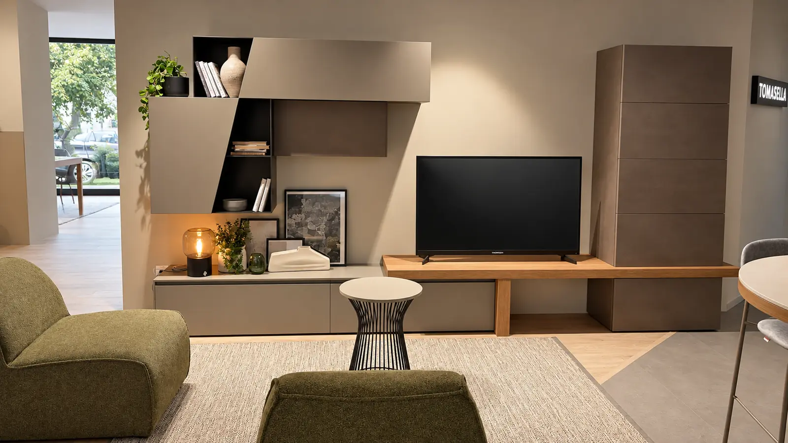 Composizione living con mensole, base in legno, televisore e poltrona verde